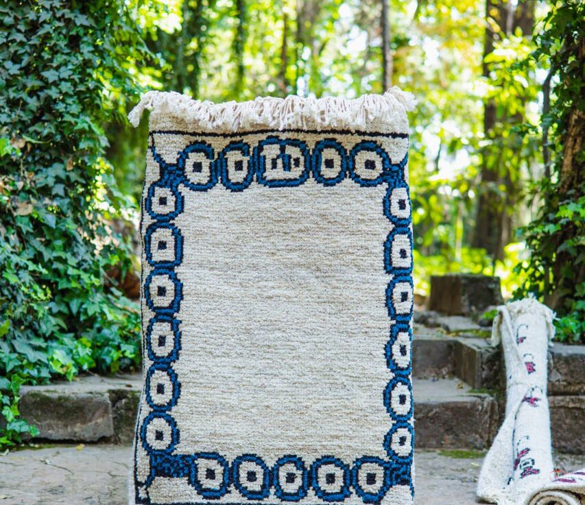 Deep blue circular motifs resembling the centers of the eye or the heart of flowers act as a protective portal, creating a sacred interior space. This instinctual design signals a safe spot built through repetitive, careful work.